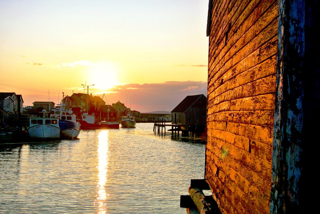 The sun is setting on Peggys Cove, a fishing village in Nova Scotia.